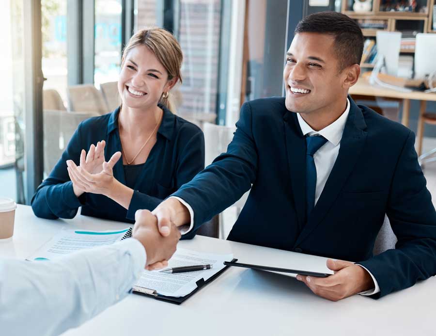 Retained executive search consultation — an ATG Partners finance recruiter shaking hands with a hiring executive across a boardroom table